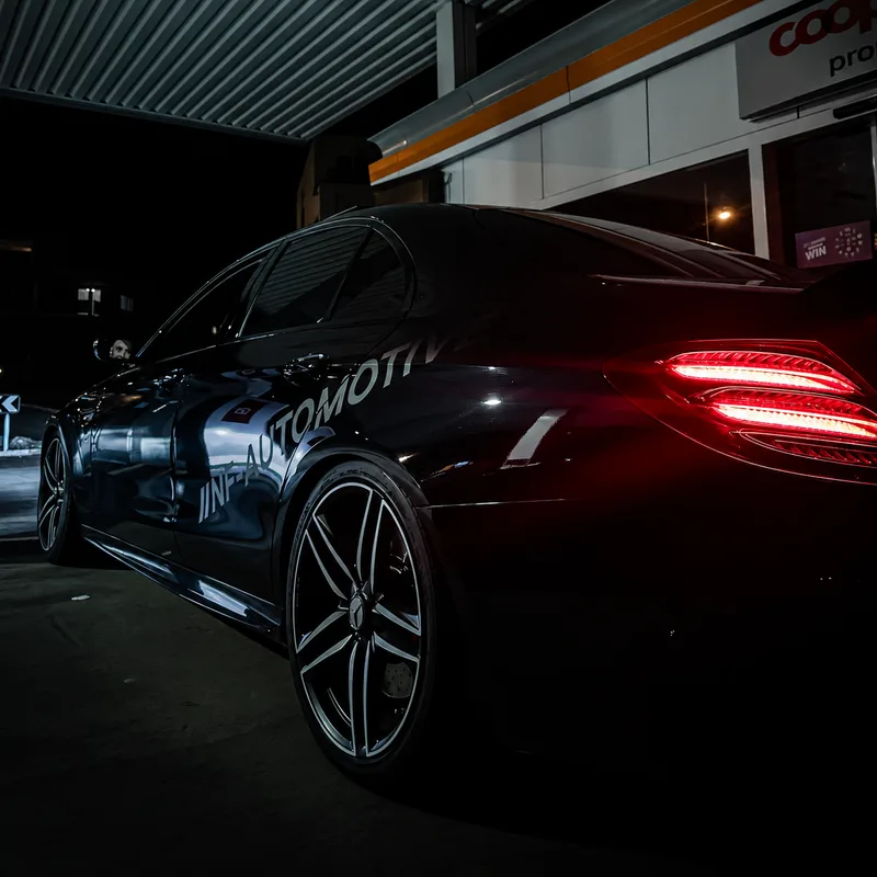 Sportwagen mit leuchtenden Rücklichtern in der NF-Automotive Werkstatt